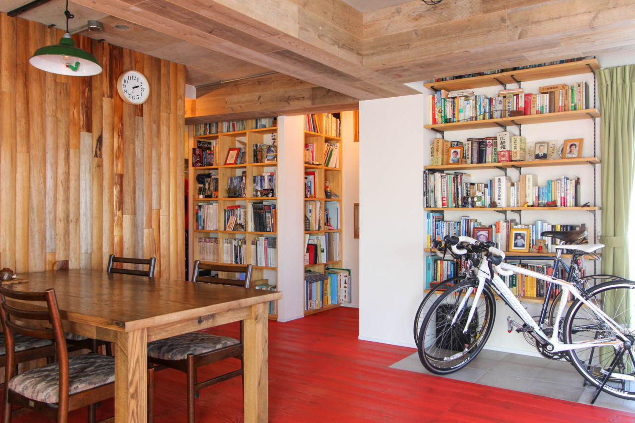 自転車と本棚と丸太の壁
