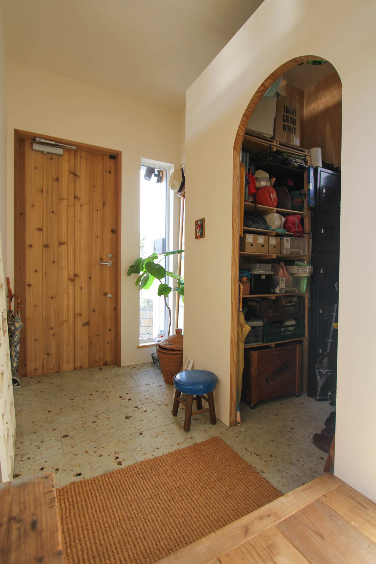木製の玄関ドアと大谷石の土間