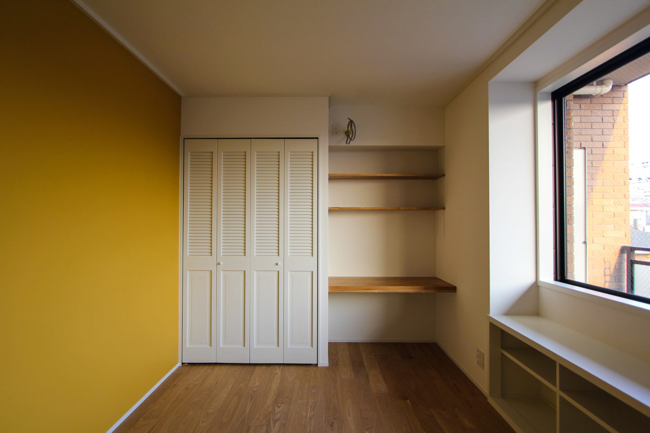 黄色い壁とデスクのある個室