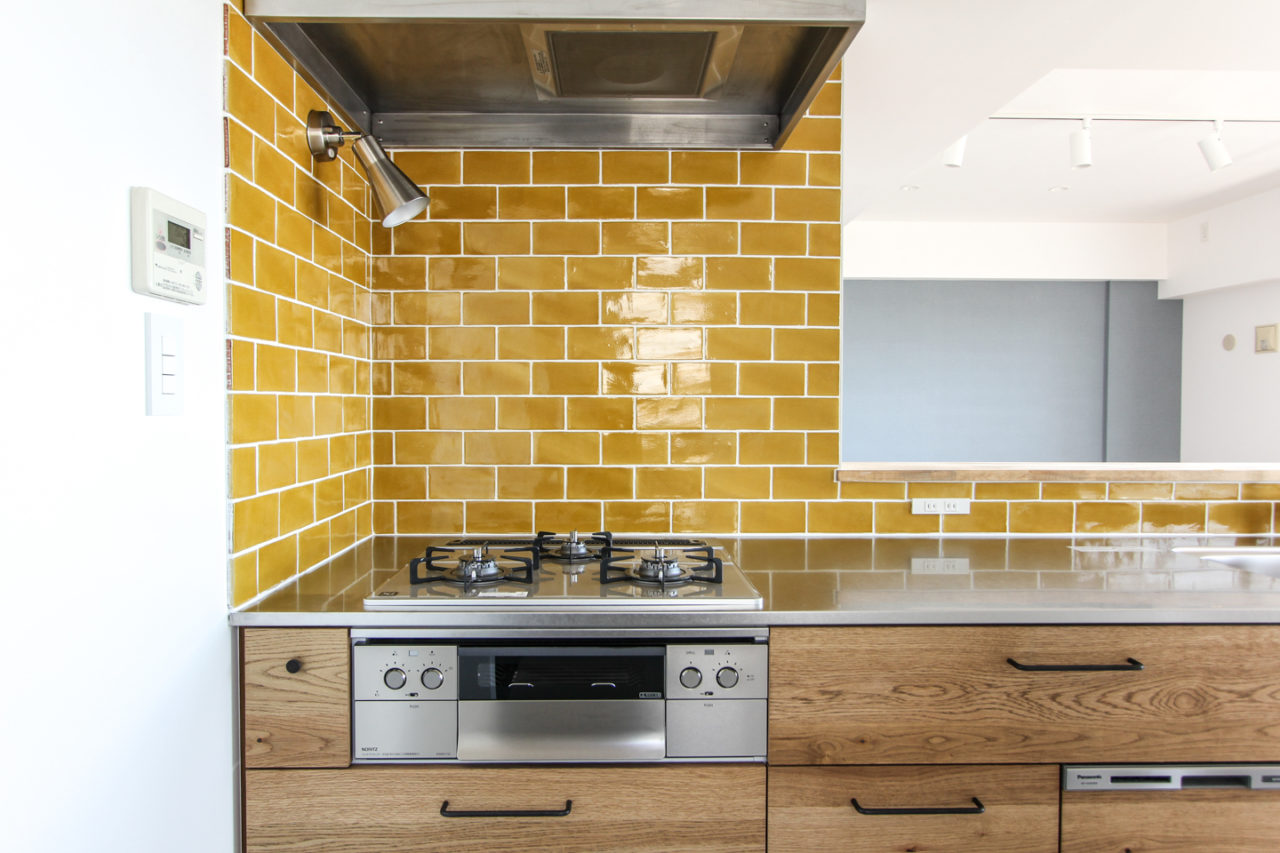 黄色いタイルの壁のキッチン