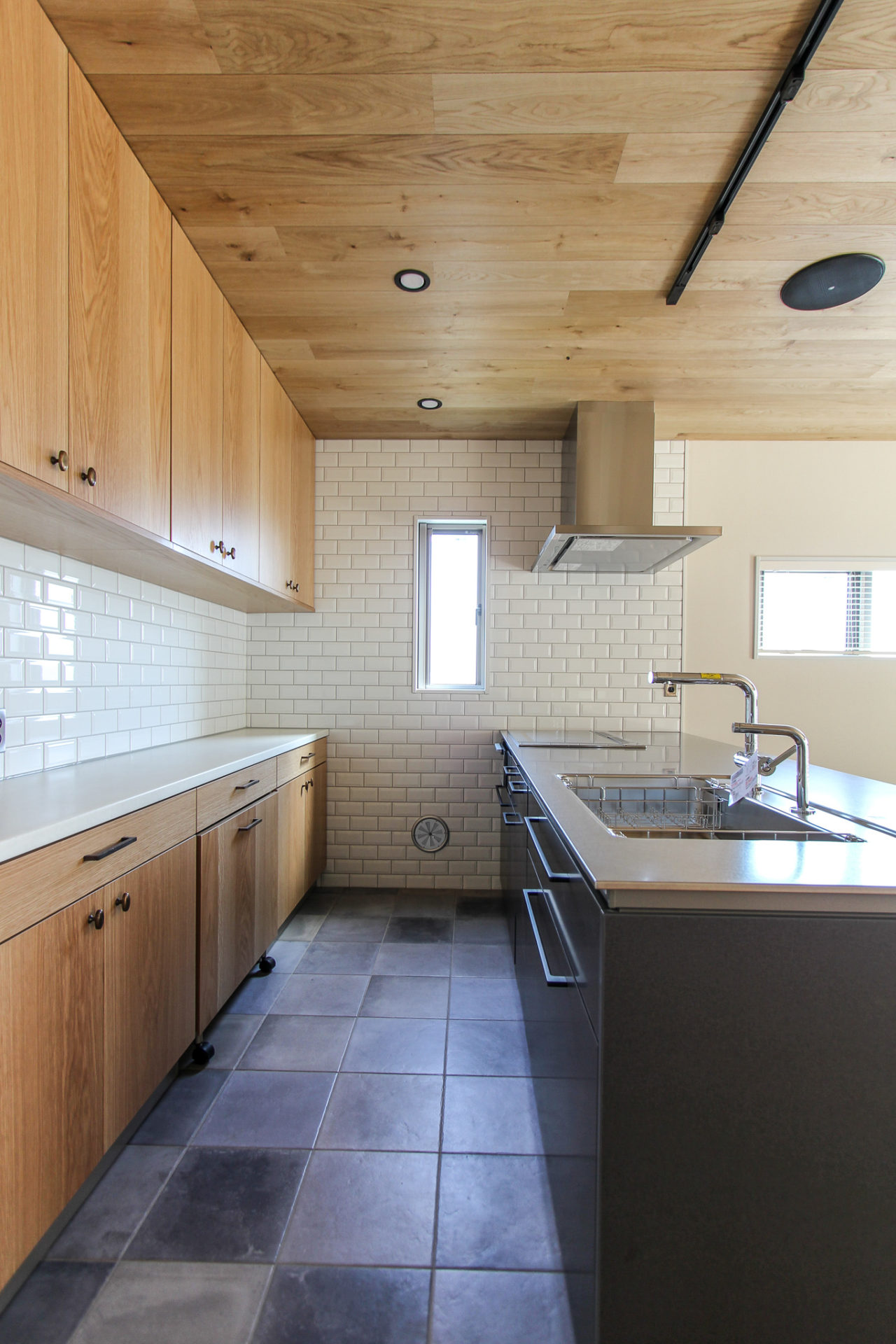 ステンレス天板と黒いキッチンと木製収納