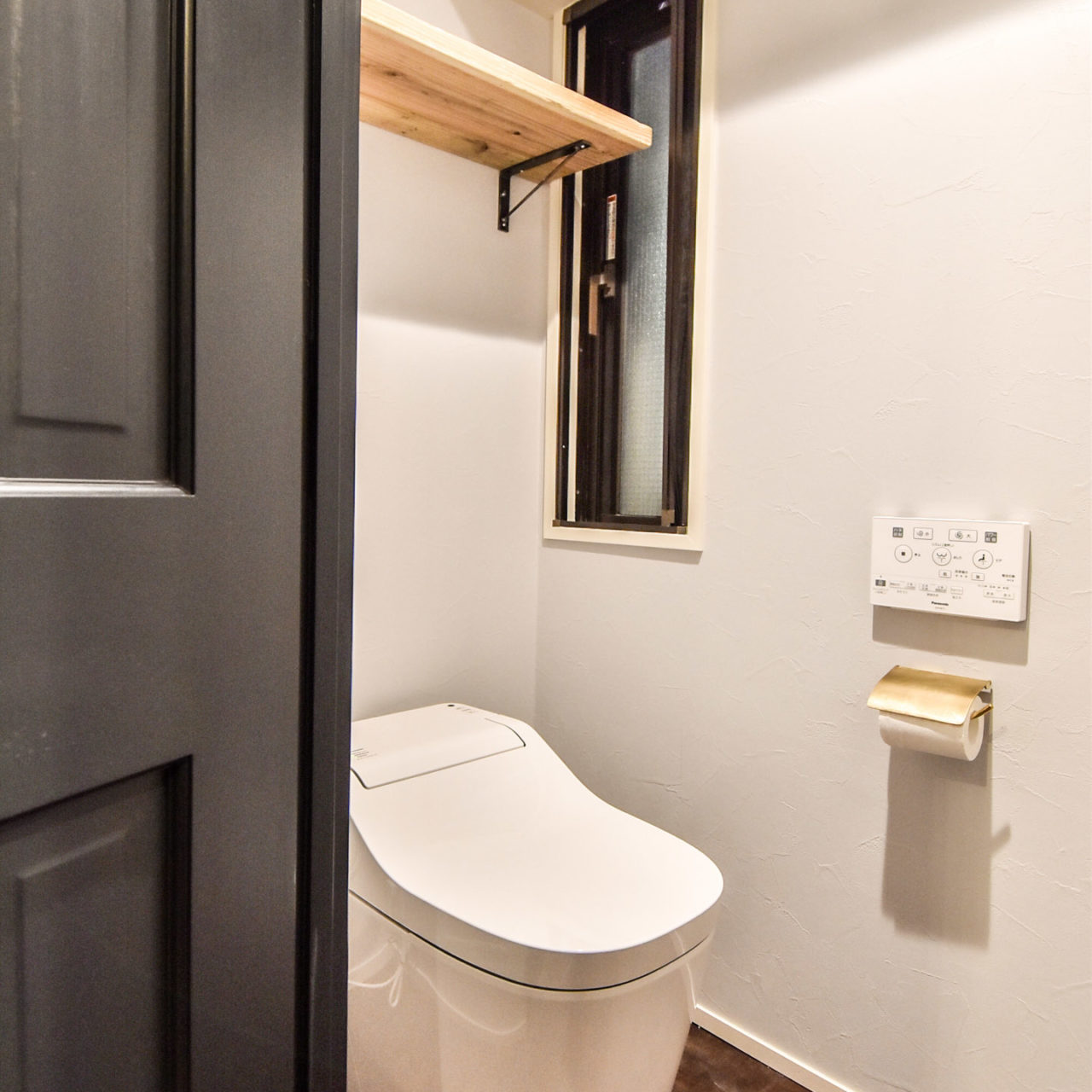 タンクレスのトイレと真鍮のペーパーホルダー