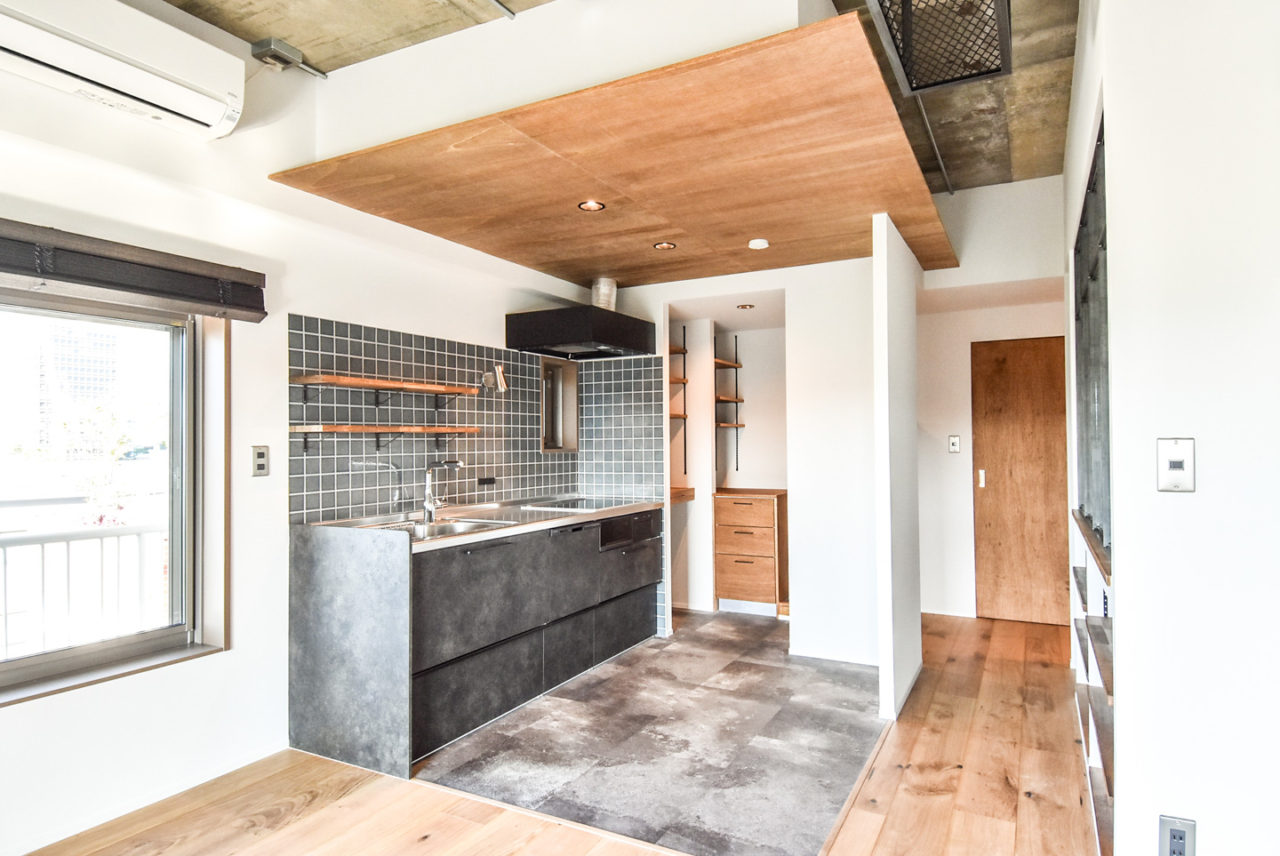 合板貼りの天井とシックなグレーのキッチンとタイル