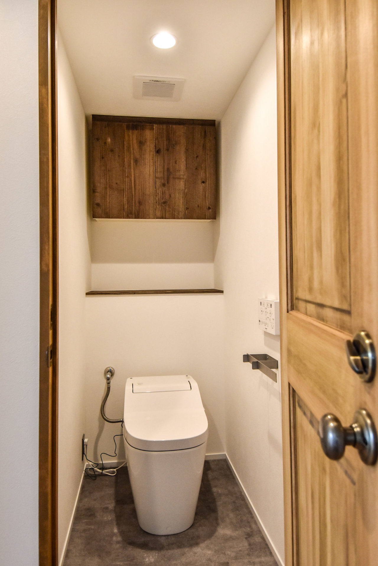 古材板貼りの吊戸棚のあるトイレ