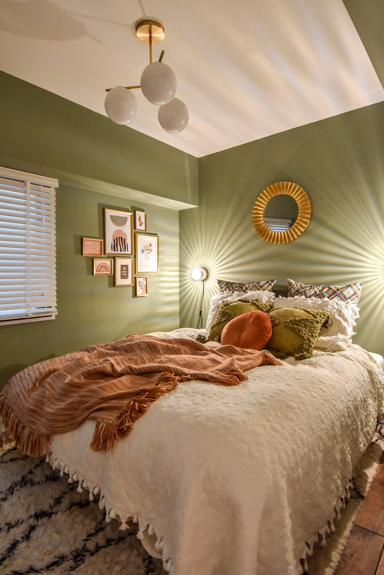 グリーンの壁と照明のあるベッドルーム