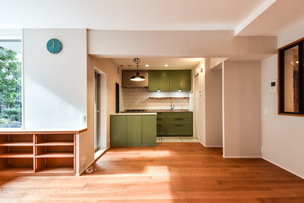 ナチュラルな床とグリーンの面材のキッチン