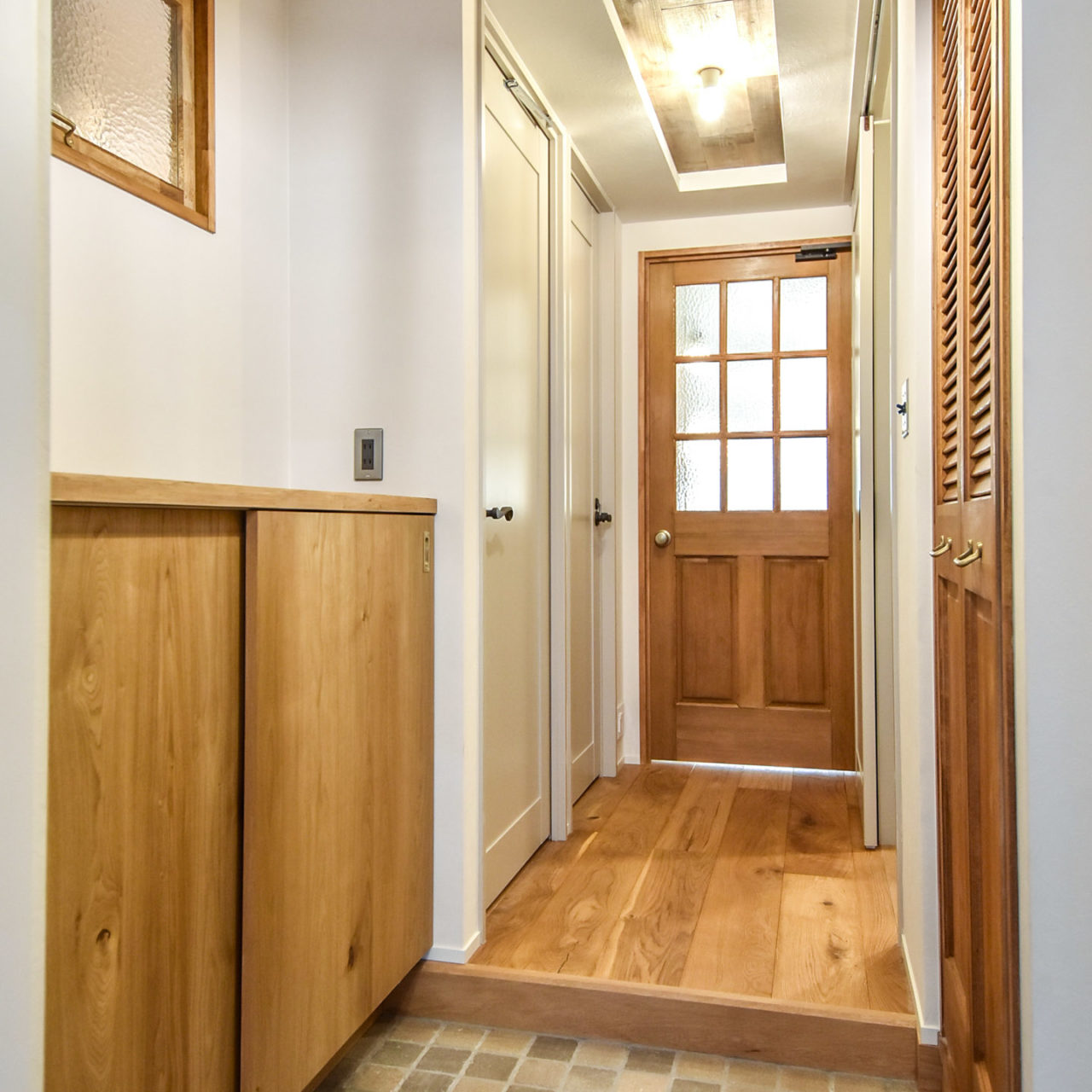 木製の玄関収納と室内窓のある玄関