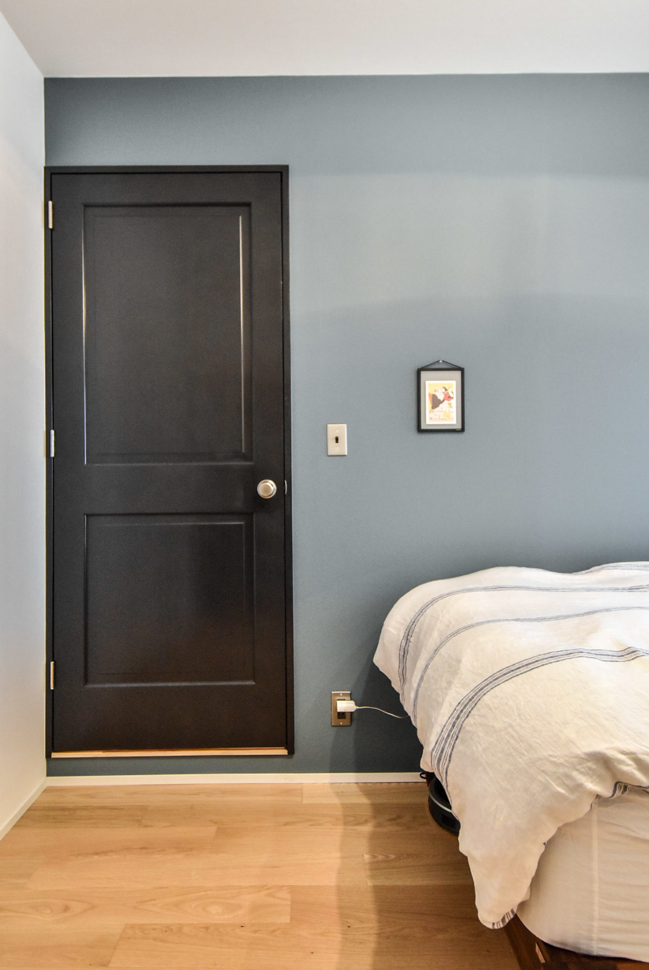 黒の扉とブルーグレーの壁の寝室