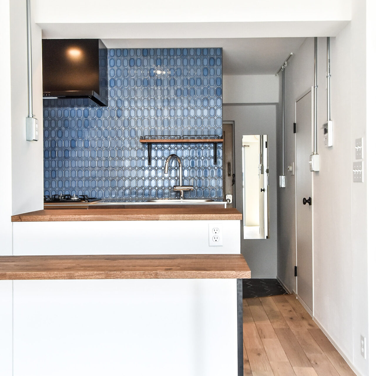ブルーのタイルの壁のキッチンと木製のカウンター