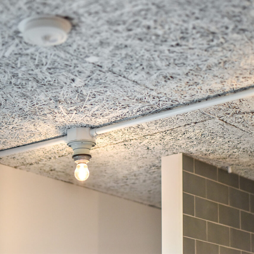 木毛セメント板の天井と白の鉄管配管