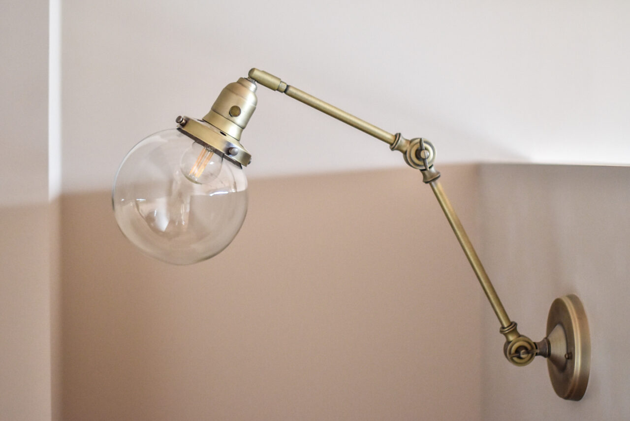 真鍮のアームと丸いガラスの電球の照明