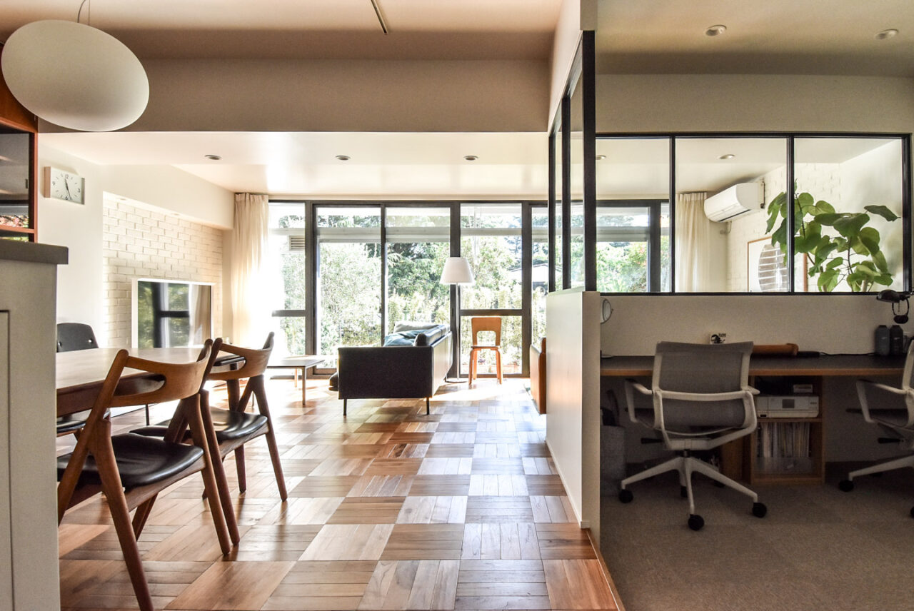 明るいリビングルームには、モダンな家具、大きな窓、木製の床があり、快適でスタイリッシュな空間を作り出しています。