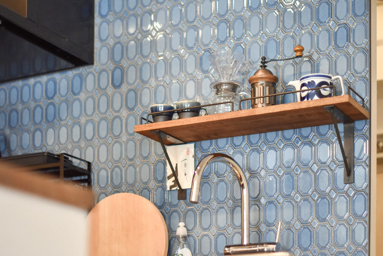 ブルーのタイルで装飾されたキッチンの棚に並ぶコーヒーカップとドリッパー