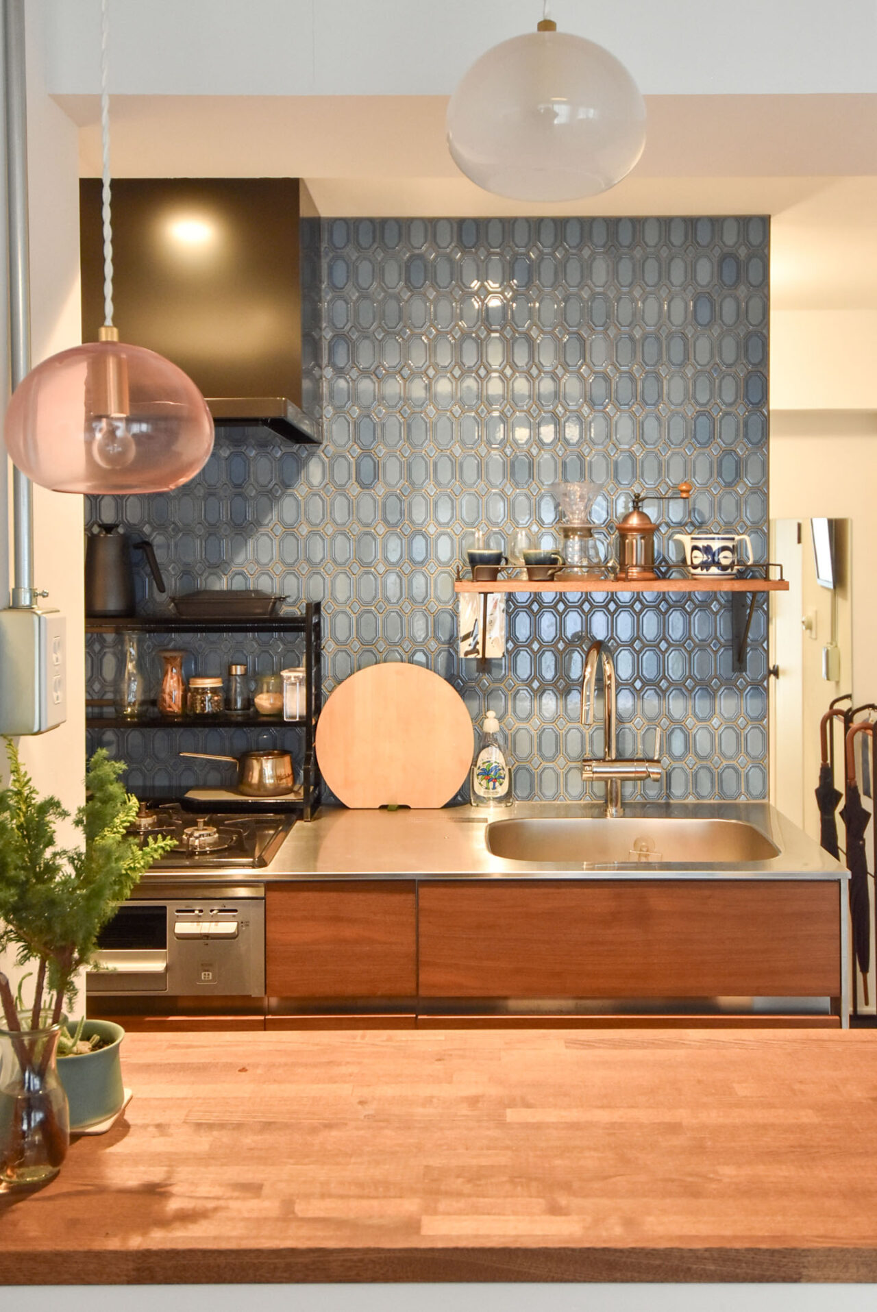 青いタイルで覆われたキッチンバックスプラッシュと木製キャビネット。