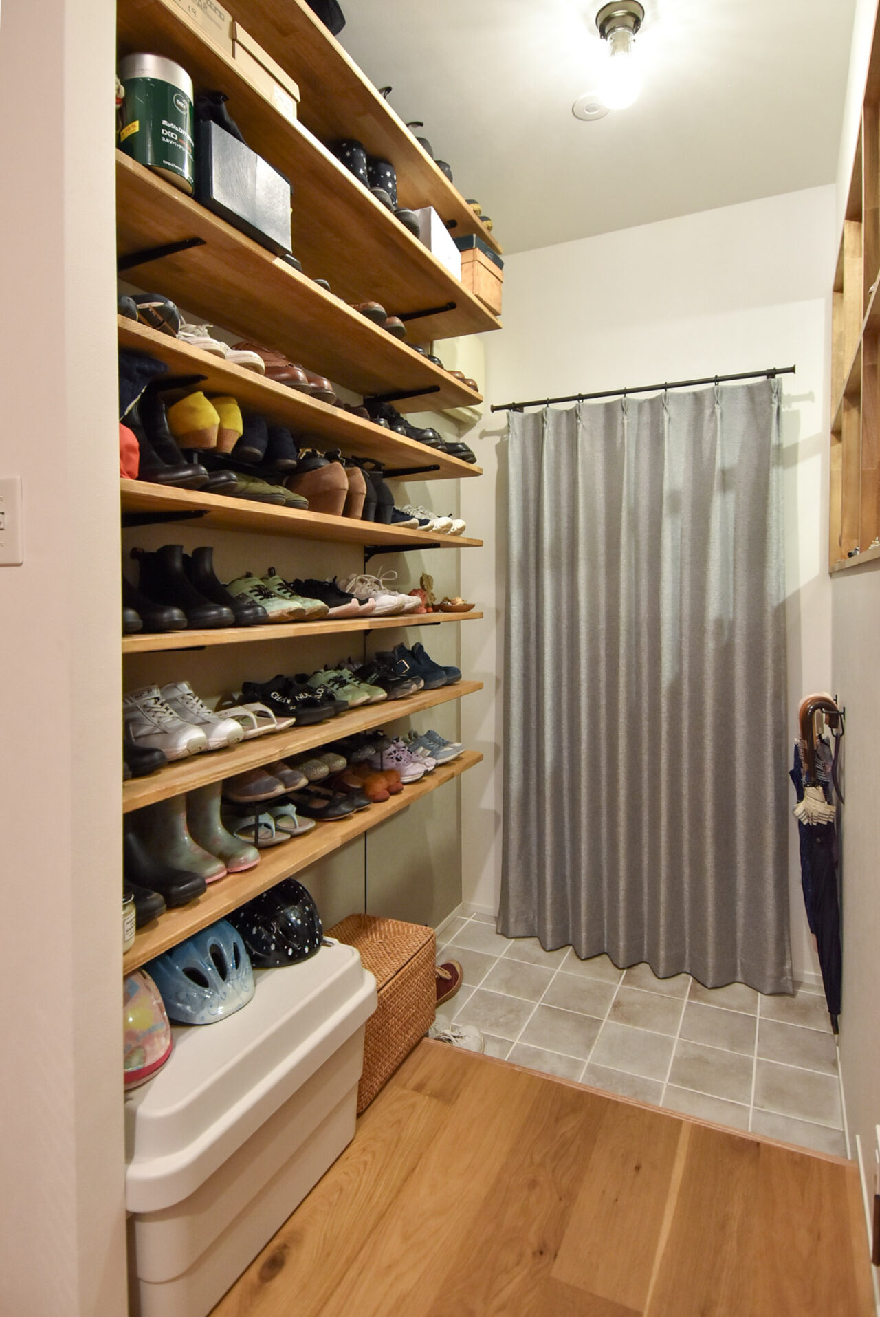 玄関ドアに掛けられたカーテンと、可動棚の靴収納