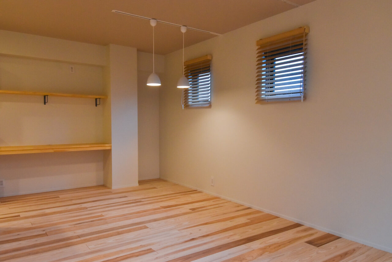 リビングルームの一角に設けられたデスクスペース。シンプルな木製の棚とデスクが機能的です。
