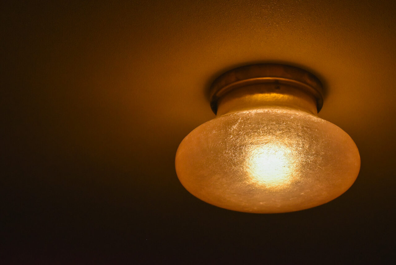 暖かみのある光を放つ、天井に取り付けられたアンティーク調のガラスのシーリングライト。